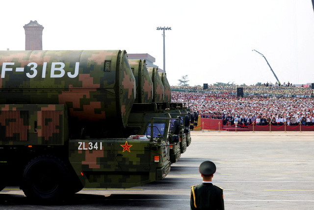 Seorang anggota Tentara Pembebasan Rakyat berdiri saat kelompok penyerang strategis memamerkan rudal nuklir DF-31BJ selama parade militer untuk memperingati 80 tahun berakhirnya Perang Dunia Kedua, di Beijing, China, Rabu (3/9/2025). Foto: Maxim Shemetov/REUTERS