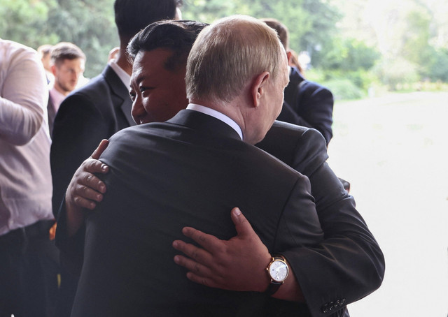 Presiden Rusia Vladimir Putin dan pemimpin Korea Utara Kim Jong-un berpelukan saat mereka meninggalkan Beijing, Rabu (3/9/2025). Foto: Sputnik/Alexander Kazakov/Pool via REUTERS