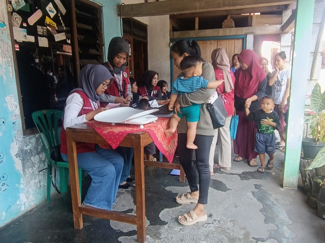 Ibu-ibu bersama balita mengantri mengisi buku tamu Foto: Moh. Habil Asshidiqi