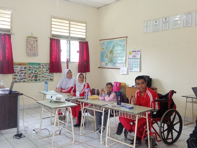 Beberapa siswa SLB-B YPAC Palembang yang sedang duduk di kelas untuk belajar/Anyelir. 