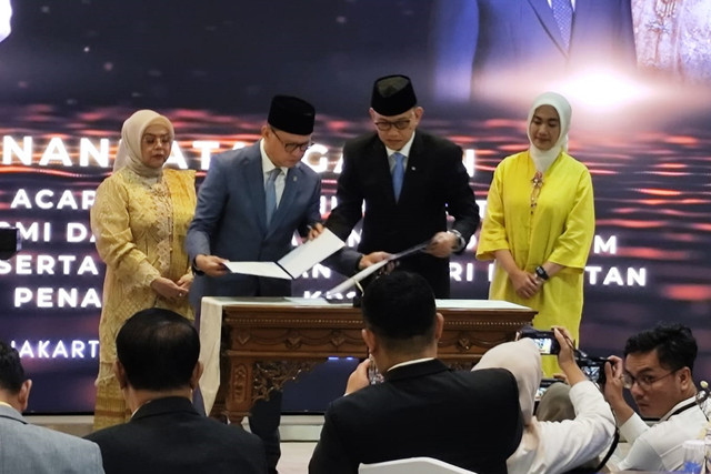 Perlindungan Pekerja Migran Indonesia (P2MI) Muktaruddin bersama pejabat lama Abdul Kadir Karding menunjukkan berita acara serah terima jabatan di Kantor Kementerian Perlindungan Pekerja Migran Indonesia (P2MI), Jakarta, Selasa (9/9/2025). Foto: Luthfi Humam/kumparan