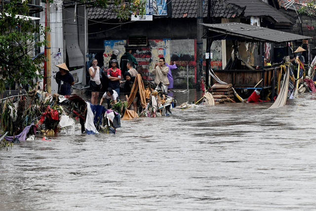 Sejumlah warga bereaksi di lingkungan yang banjir akibat hujan deras di Denpasar, Bali, Rabu (10/9/2025). Foto: Sonny Tumbelaka/AFP