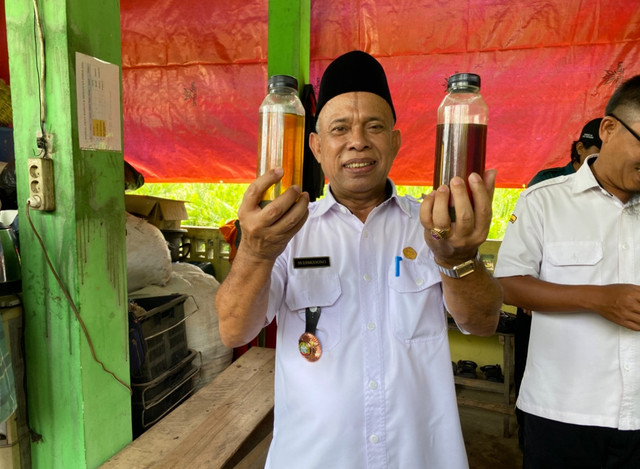 Kepala Dinas Lingkungan Hidup Kota Pontianak,Syarif Usmulyono memperlihatkan minyak bakar yang dibuat dari sampah. Foto: Yulia Ramadhiyanti/HiPontianak