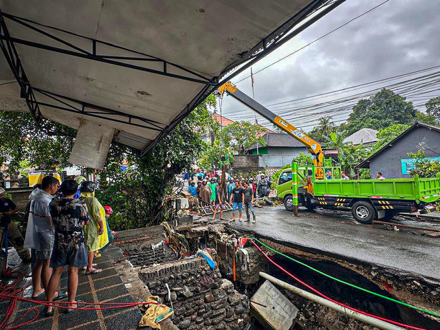 Proses evakuasi mobil Sigra dan penumpangnya yang hanyut dan terperosok ke got akibat banjir di Badung, Bali. Foto: Dok. Polres Badung