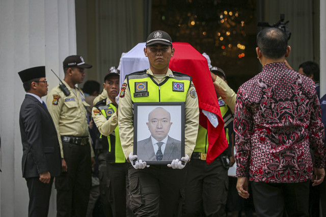 Seorang petugas membawa bingkai foto saat penghormatan terakhir kepada jenazah Zetro Leonardo Purba, staf Kedutaan Besar Republik Indonesia (KBRI) yang diduga tewas ditembak di Peru, di Gedung Kementerian Luar Negeri, Jakarta, Kamis (11/9/2025). Foto: Aditia Noviansyah/kumparan