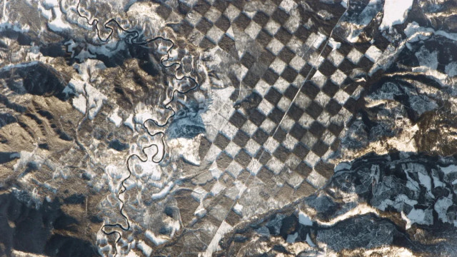 Jika dilihat dari luar angkasa, hamparan hutan ini tampak seperti papan catur raksasa berkat sistem manajemen berbasis grid dan lapisan salju. Foto: NASA/ISS