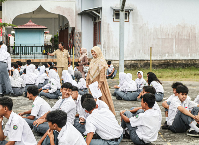 Guru membimbing siswa dalam kegiatan di halaman sekolah, menekankan pentingnya penguatan pendidikan karakter melalui kebersamaan dan disiplin.Sumber foto: Fajar Herlambang STUDIO,(https://unsplash.com)