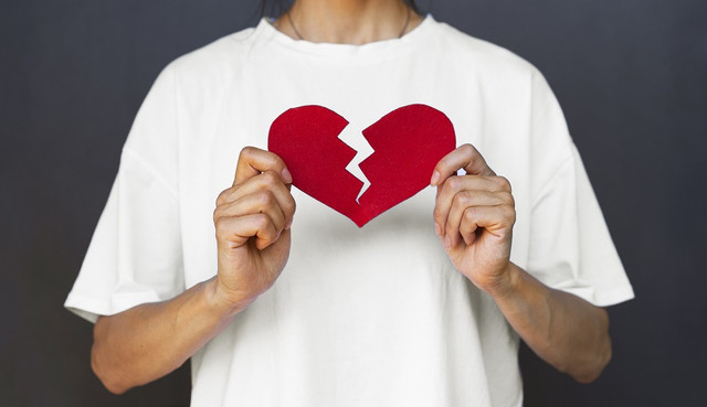 www.freepik.com/free-photo/front-view-adult-holding-red-broken-heart