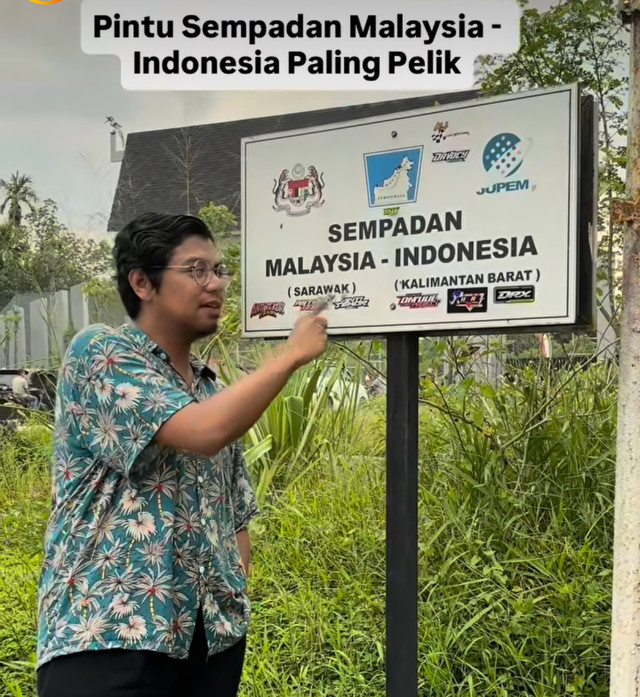 Traveler asal Malaysia, Tun Arie menunjukkan papan nama perbatasan Sempadan Malaysia-Indonesia. Foto: Dok. instagram @arieenisme