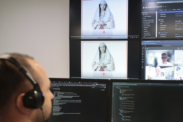 Seorang pakar Albania bekerja di Badan Nasional untuk Masyarakat Informasi sebagai "menteri" kecerdasan buatan bernama Diella yang terlihat di layar di Tirana, Albania, Jumat (12/9/2025). Foto: Vlasov Sulaj/AP Photo