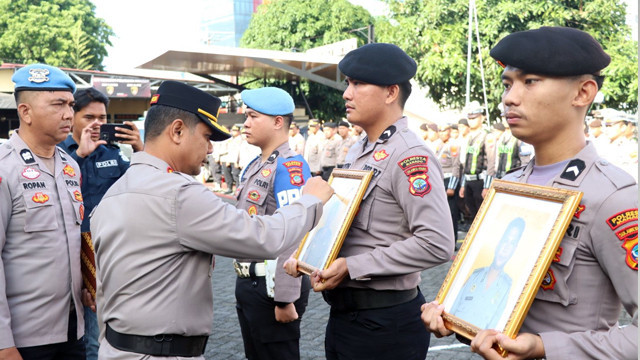 Kapolrestas Manado, Kombes Pol Irham Halid, memberikan tanda silang merah ke foto polisi yang diberhentikan dengan tidak hormat (PTDH), tanda pelepasan kedinasan Polri. (foto: istimewa)