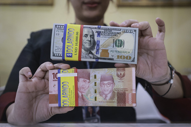 Petugas menunjukkan uang pecahan rupiah dan dolar AS di gerai penukaran mata uang asing Dolarindo, Melawai, Jakarta, Senin (15/9/2025). Foto: Dhemas Reviyanto/ANTARA FOTO