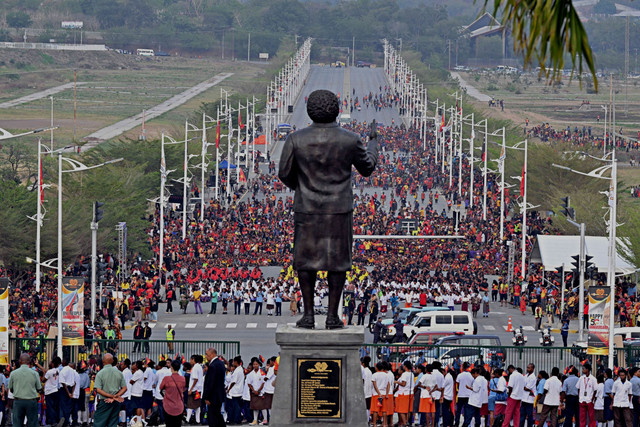 Orang-orang berdiri di depan patung Perdana Menteri pertama Papua Nugini, Michael Somare, saat upacara pengibaran bendera di Port Moresby, Papua Nugini, Selasa (16/9/2025). Foto: AAP/Mick Tsikas via Reuters