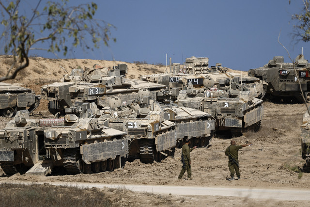 Tentara Israel berdiri di samping kendaraan tempur lapis baja (APC) di dekat perbatasan Israel-Gaza, di Israel, Selasa (16/9/2025). Foto: Amir Cohen/REUTERS