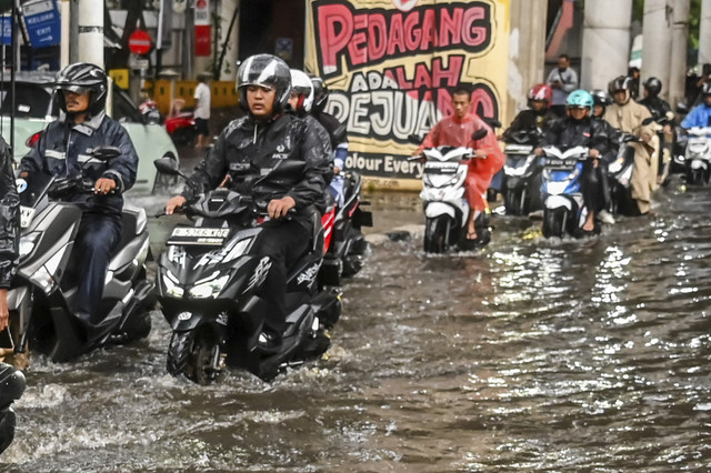 Sejumlah pengendara melintasi genangan air usai hujan deras di depan Pasar Cipulir, Jakarta, Selasa (16/9/2025). Foto: Rivan Awal Lingga/ANTARA FOTO