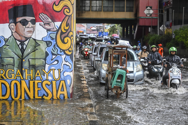 Sejumlah pengendara melintasi genangan air usai hujan deras di depan Pasar Cipulir, Jakarta, Selasa (16/9/2025). Foto: Rivan Awal Lingga/ANTARA FOTO