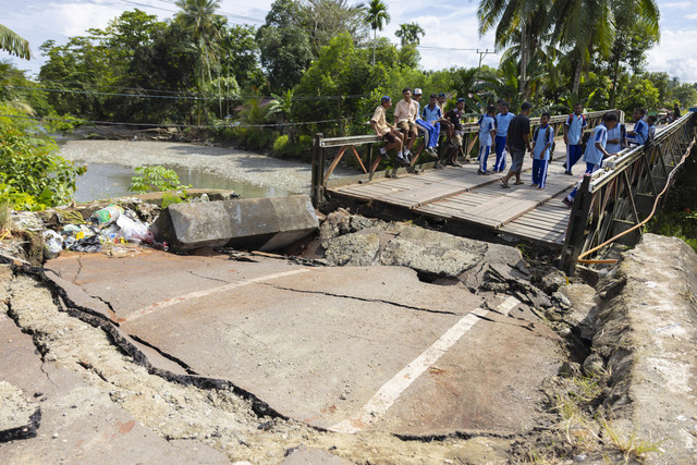 Sejumlah pelajar mengamati jembatan Siriwini Bawah yang rusak akibat gempa di Kabupaten Nabire, Provinsi Papua Tengah, Jumat (19/9/2025). Foto: Jack/ANTARA FOTO