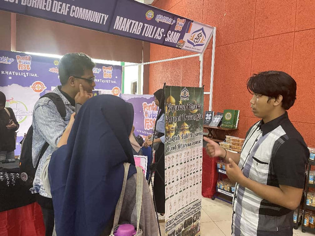 Pengunjung tampak mencoba berkomunikasi menggunakan bahasa isyarat bersama tim dari West Borneo Deaf Community (WBDC) Kalimantan Barat. Foto: Alycia Tracy Nabila/Hi!Pontianak