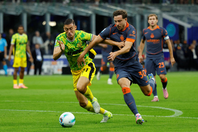 Pemain Inter Milan Carlos Augusto berusaha melewati pemain Sassuolo Jay Idzes pada pertandingan Liga Italia di San Siro, Milan, Italia, Minggu (21/9/2025). Foto: Alessandro Garofalo/REUTERS