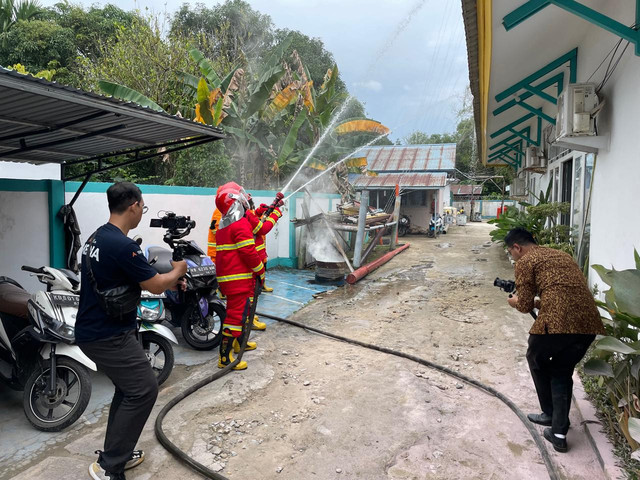 Para petugas sigap mempraktikkan simulasi pemadaman kebakaran dalam rangkaian Sosialisasi K3 & KAM serta Simulasi Tanggap Darurat yang digelar PLN UP3 Ketapang. Foto: Dok. PLN Ketapang