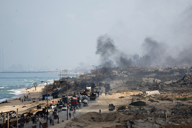 Warga Palestina yang mengungsi dari Gaza utara akibat operasi militer Israel, bergerak ke selatan di sepanjang area yang hancur setelah pasukan Israel memerintahkan penduduk Kota Gaza untuk mengungsi ke selatan, di Jalur Gaza tengah, (23/9). Foto: REUTERS/Mahmoud Issa
