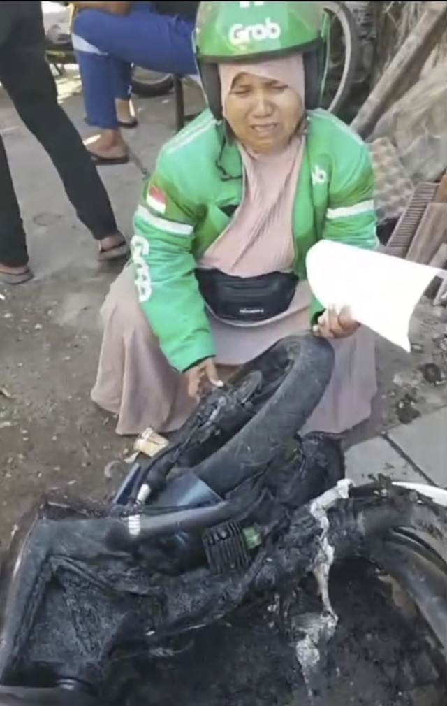 Saripah, ojol di Makassar menangis melihat motor miliknya dibakar massa tawuran, Senin (22/9/2025). Foto: Dok. Istimewa