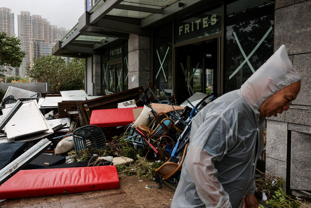 Seorang pria berjalan di samping restoran yang rusak akibat Topan Super Ragasa di Hong Kong, China, Rabu (24/9/2025). Foto: Tyrone Siu/REUTERS