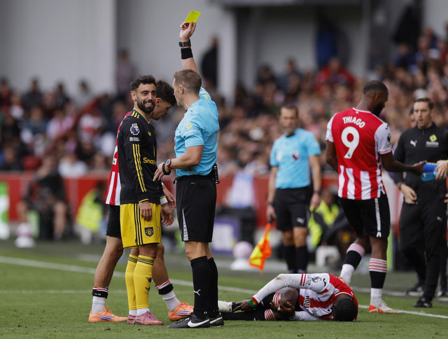 Bruno Fernandes dari Manchester United menerima kartu kuning dari wasit Craig Pawson. Foto: Reuters/Andrew Couldridge
