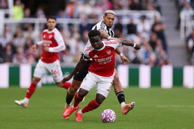 Pemain Newcastle United Joelinton berebut bola dengan pemain Arsenal Bukayo Saka pada pertandingan Liga Inggris di St James' Park, Newcastle, Inggris, Minggu (28/9/2025). Foto: Lee Smith/REUTERS