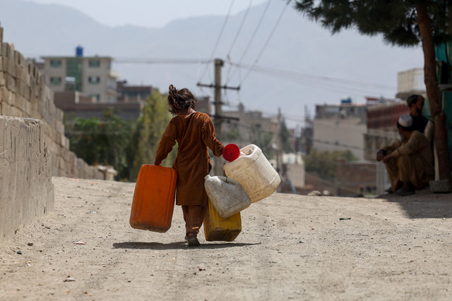 Seorang gadis membawa tong-tong kosong untuk mengambil air, di tengah krisis air yang parah di Kabul, Afghanistan. Foto: REUTERS/Sayed Hassib