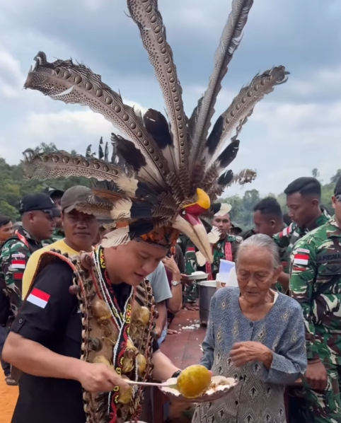 Bobon Santoso berbagi makanan gratis sambil memakai baju adat Dayak di Kabupaten Sintang, Kalimantan Barat. Foto: Dok. Instagram @bobonsantoso