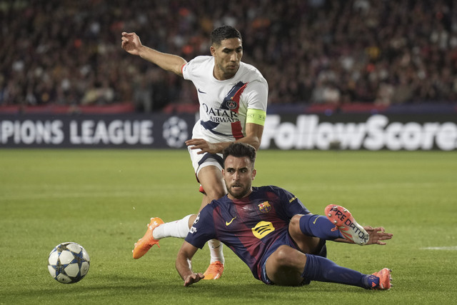 Achraf Hakimi dari PSG berebut bola dengan Eric Garcia dari Barcelona dalam pertandingan Liga Champions antara Barcelona vs Paris Saint-Germain di Stadion Olimpiade Lluis Compays di Barcelona, Rabu (1/10/2025). Foto: Emilio Morenatti/AP Photo