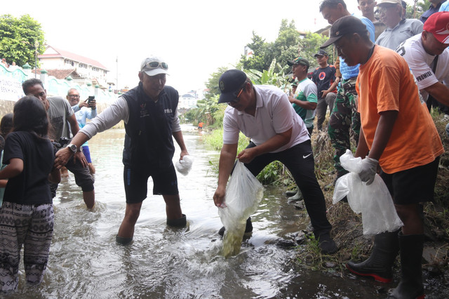 Wali Kota Yogyakarta, Hasto Wardoyo, menebar benih ikan di Kali Code, Sabtu (4/10). Foto: Dok. Pemkot Yogya