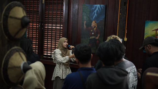 Indah ketika mempresentasikan lukisan berjudul Angngaru' di event Menjaring Tutur. Sumber: Tim Dokumentasi Menjaring Tutur