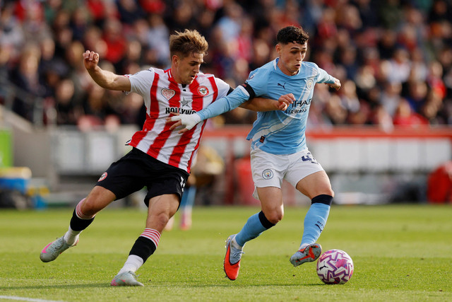 Pemain Brentford Yehor Yarmolyuk berebut bola dengan pemain Manchester City Phil Foden pada pertandingan Liga Inggris di Stadion Komunitas GTech, London, Inggris, Minggu (5/10/2025). Foto: Andrew Couldridge/REUTERS