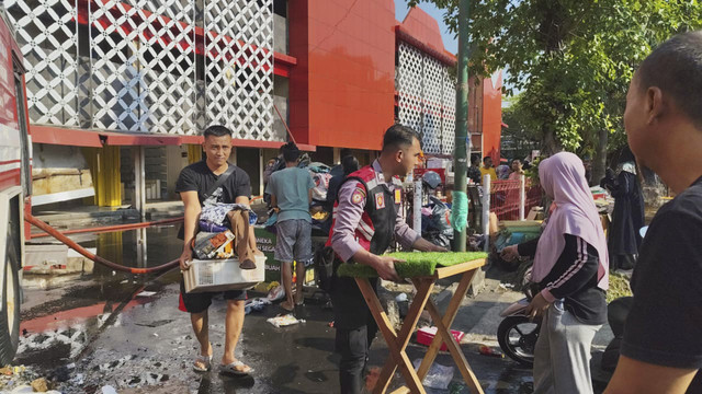 Petugas kepolisian mengevakuasi barang dagangan saat kebakaran di Pasar Wonogiri. Foto: Dok Humas Polres Wonogiri