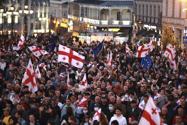 Para pendukung oposisi dengan bendera nasional Georgia dan Uni Eropa berkumpul untuk memboikot pemilihan umum kota dan menuntut pembebasan lawan politik di pusat kota Tbilisi, Georgia, pada Sabtu (4/10/2025). Foto: Zurab Tsertsvadze/AP Photo
