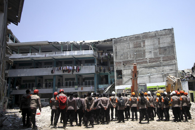 Anggota kepolisian melihat bangunan pasca penutupan operasi SAR di Pondok Pesantren (Ponpes) Al Khoziny di Kecamatan Buduran, Sidoarjo, Jawa Timur, Selasa (7/10/2025). Foto: Umarul Faruq/ANTARA FOTO