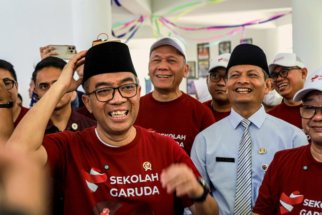 Mendikti Brian Yuliarto (kiri) mencoba karya ilmiah yang dipresentasikan siswa saat pengenal Sekolah Garuda Harapan Baru Pendidikan Unggul di SMA Negeri Unggulan MH Thamrin, Bambu Apus, Jakarta Timur, Rabu (7/10/2025). Foto: Darryl Ramadhan/kumparan