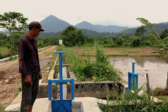 Rizky Hidayat, petani asal Gampong Meudhang Ghon, melihat aliran air dari saluran irigasi yang kini mampu mengairi sawah warga secara merata. Foto: Dok. Istimewa