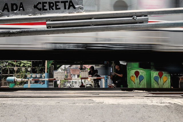 Warga berjaga saat kereta Commuter Line melintas di dekat palang perlintasan rel kereta api sebidang di kawasan Tebet Timur, Jakarta, Sabtu (11/10/2025). Foto: Darryl Ramadhan/kumparan