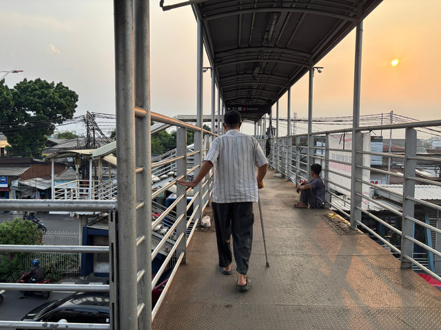Pria tuna netra paruh baya yang melintasi JPO Kramat Jati, Jakarta Timur pada Sabtu (11/10/2025) sore. Foto: Amira Nada Fauziyyah/kumparan