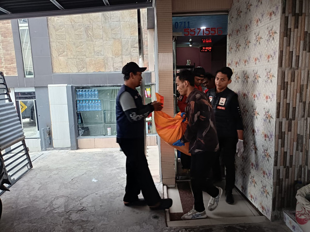 Anggota polisi saat mengevakuasi jenazah perempuan yang tewas di kamar hotel kawasan Boom Baru, Palembang. Foto : Istimewa