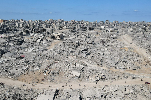 Warga berjalan di tengah kehancuran di Kota Gaza, Jalur Gaza utara, Sabtu (11/10/2025). Foto: AFP