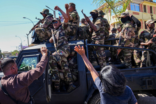 Para tentara disambut oleh warga yang berkumpul untuk upacara penghormatan kepada para demonstran yang tewas dalam protes anti-pemerintah di pusat kota Antananarivo, Madagaskar, Minggu (12/10/2025). Foto: Alexander Joe/AP PHOTO