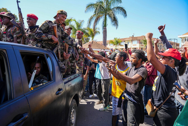Para tentara disambut oleh warga yang berkumpul untuk upacara penghormatan kepada para demonstran yang tewas dalam protes anti-pemerintah di pusat kota Antananarivo, Madagaskar, Minggu (12/10/2025). Foto: Alexander Joe/AP PHOTO