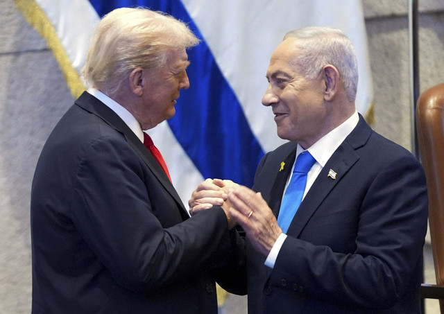 Presiden Donald Trump berbincang dengan Perdana Menteri Israel Benjamin Netanyahu di Knesset, Yerusalem, Senin (13/10/2025). Foto: Evan Vucci/Pool via Reuters