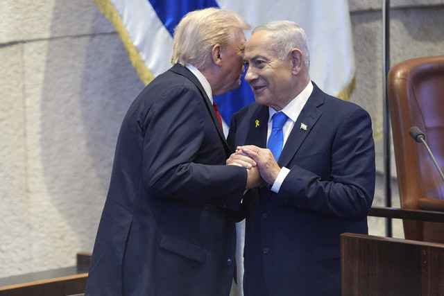 Presiden Donald Trump berbincang dengan Perdana Menteri Israel Benjamin Netanyahu di Knesset, Yerusalem, Senin (13/10/2025). Foto: Evan Vucci/Pool via Reuters