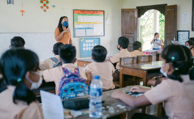 Seorang guru sedang mengajar di depan kelas (Sumber: Agung Pandit Wiguna:https://www.pexels.com/photo/woman-teaching-children-in-a-classroom-12125962/