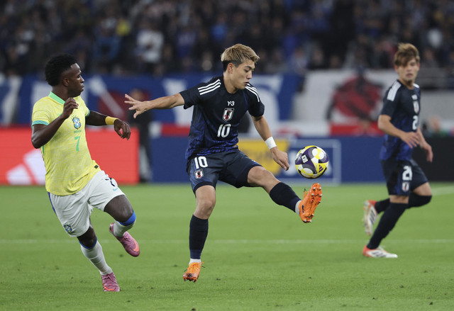 Ritsu Doan dari Jepang beraksi bersama Vinicius Jr. dari Brasil pada pertandingan persahabatan antara Jepang vs Brasil di Stadion Tokyo, Tokyo, Jepang, Selasa (14/10/2025). Foto: Kim Kyung-Hoon/REUTERS